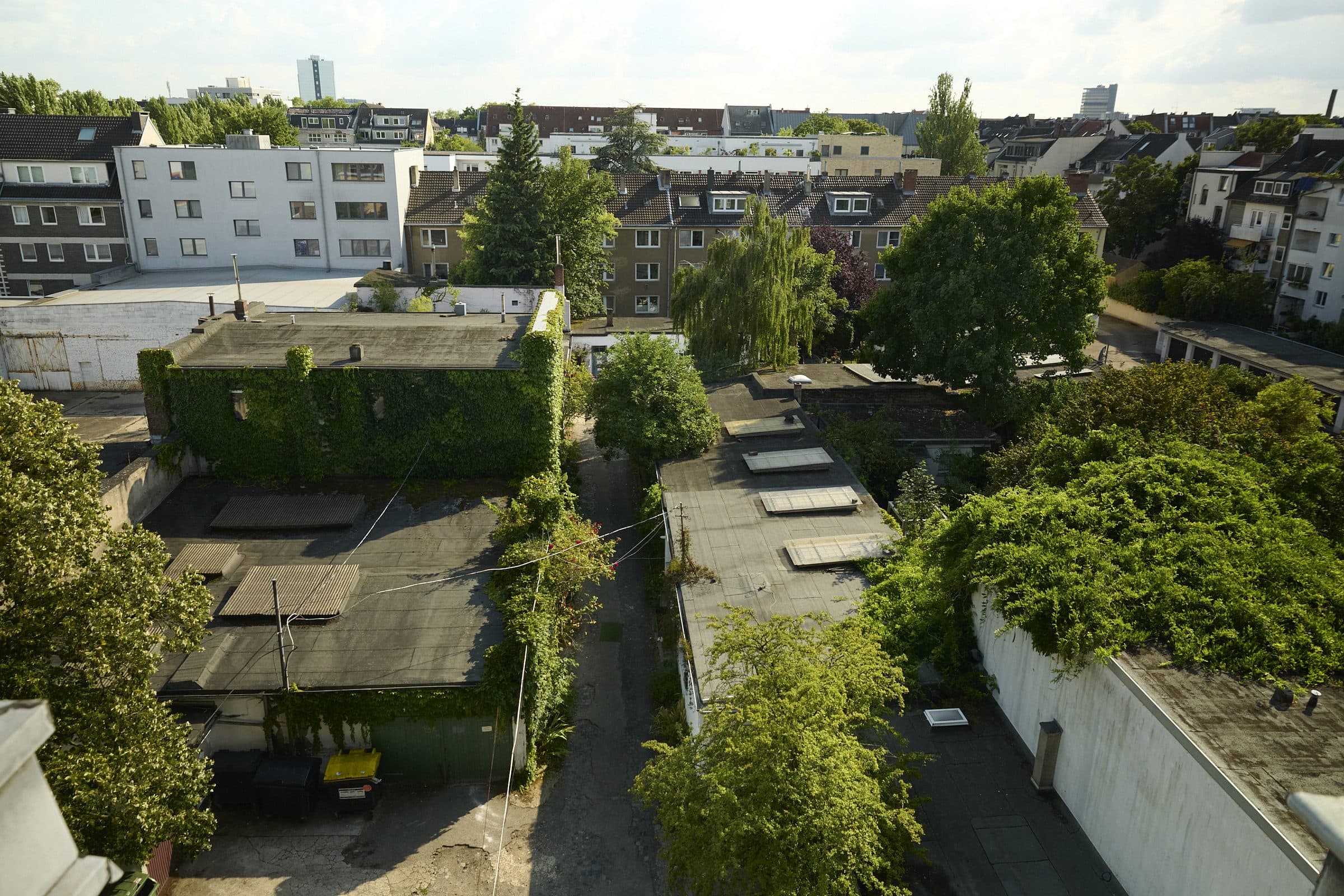 Luftaufnahme des historischen Hinterhof-Ensembles der Rosenhöfe – Blick über die Dächer bis nach Ehrenfeld